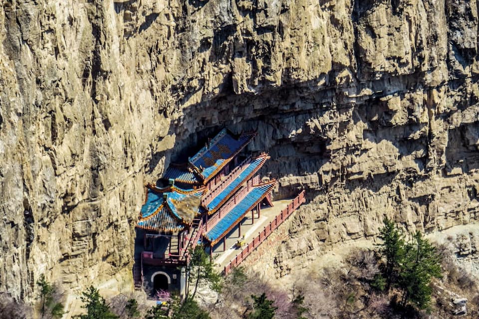 Een traditionele Chinese tempel verscholen in een rotswand.