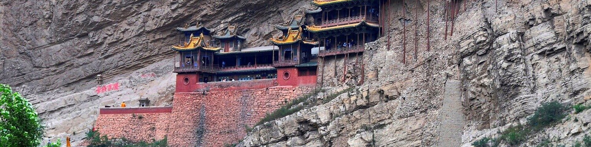 Conjunto de templos chineses tradicionais construídos na encosta de um penhasco.