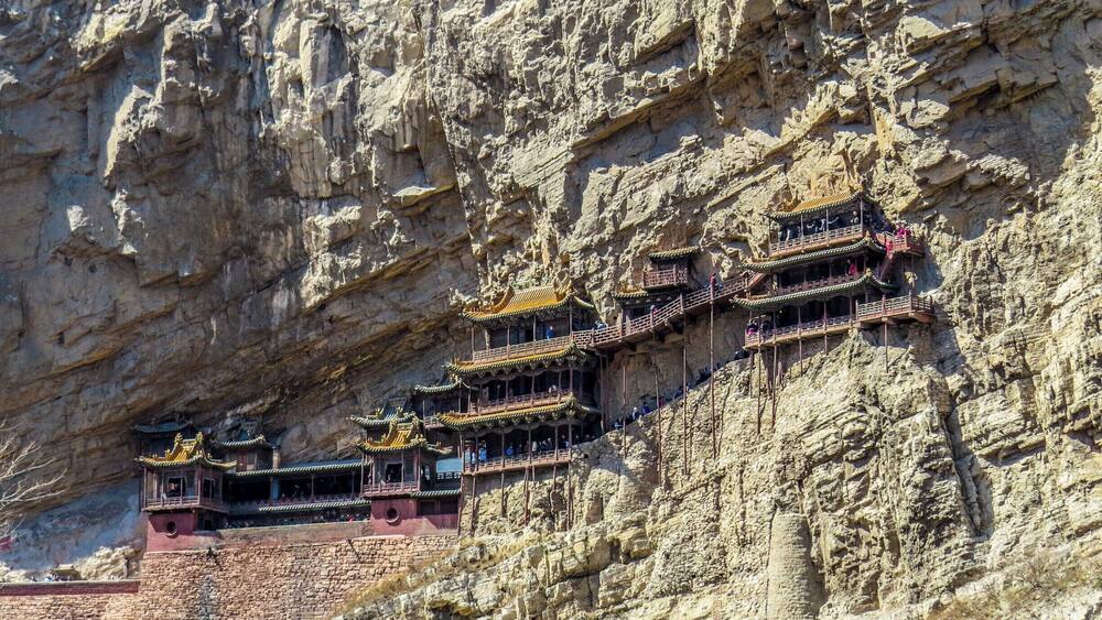 A series of traditional Chinese temples built into a cliffside.