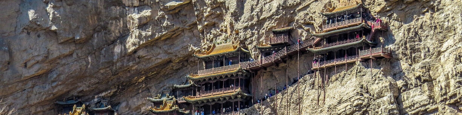 A series of traditional Chinese temples built into a cliffside.