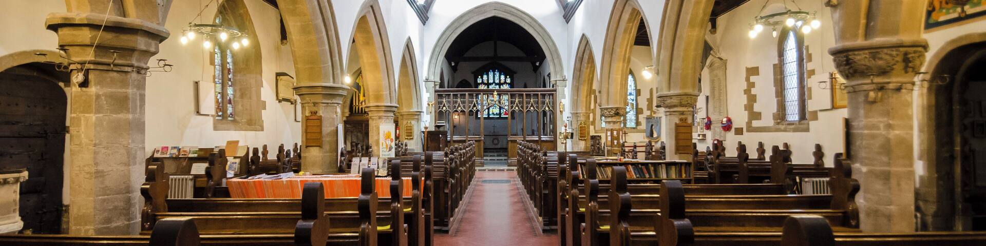 Balderton dates back to Saxon times, and it is known that Lady Godiver the wife of Earl Leofric had property nearby. In the past the Great North Road from London to York passed through the village. There is no trace of an original Saxon church, although one probably existed. The church dates from the 12th century when a simple building, some of which still remains in the nave, was constructed. The north and south doorways still retain Norman arches with zigzag patterning (although both have been moved from their original position). The church consists of a tower with spire, nave with north and south aisles, north and south porches, and a chancel with north Chapel which houses the organ. The tower dates from the 13th century and is of three stages. It was encased in ashlar in the 1880s. The top is embattled with pinnacles and gargoyles. The spire dates from circa 1400 and is crocketted with lucarnes. There are 8 bells. The nave has four bay arcades with octagonal piers. In the 13th century the north aisle was added and a larger chancel was built. Shortly after, the nave was extended westward, and the building of the tower commenced, this was delayed by the Black Death of 1347. The south aisle was added in the 14th century. The font also dates from this time. It is octagonal, with ball flower ornamentation. Around this time a clerestory was added, which was later removed in Victorian times. The screen dates from the 15th century and it was originally brightly painted and had panels of Biblical scenes. Evidence of the stonework supporting the rood loft was removed during restoration in 1882. In the late 15th century the pews were installed. These have carved poppy heads depicting animals and other figures, one man is playing Lincolnshire bagpipes. There are also undecorated 19th-century pews. The pulpit is from around 1475 and was previously on the south side of the chancel arch but was moved in 1882. The north door with its wicket is of the same 15th century period. The Victorian restoration of the church took place in 1882, when the nave roof was altered and the clerestory removed. The chancel roof had already been replaced in 1850, and additional pews were installed. The north porch was rebuilt incorporating the Norman arch. In 1929 cracks were found in the tower wall and major repairs to the foundations were undertaken. A new vestry was constructed in 1964 on the south side of the church. In 1983 the chancel was encased in Ancaster stone, matching the rest of the church. There are several 19th-century stained-glass windows and some reset fragments of 15th century glass which were found in the churchyard.