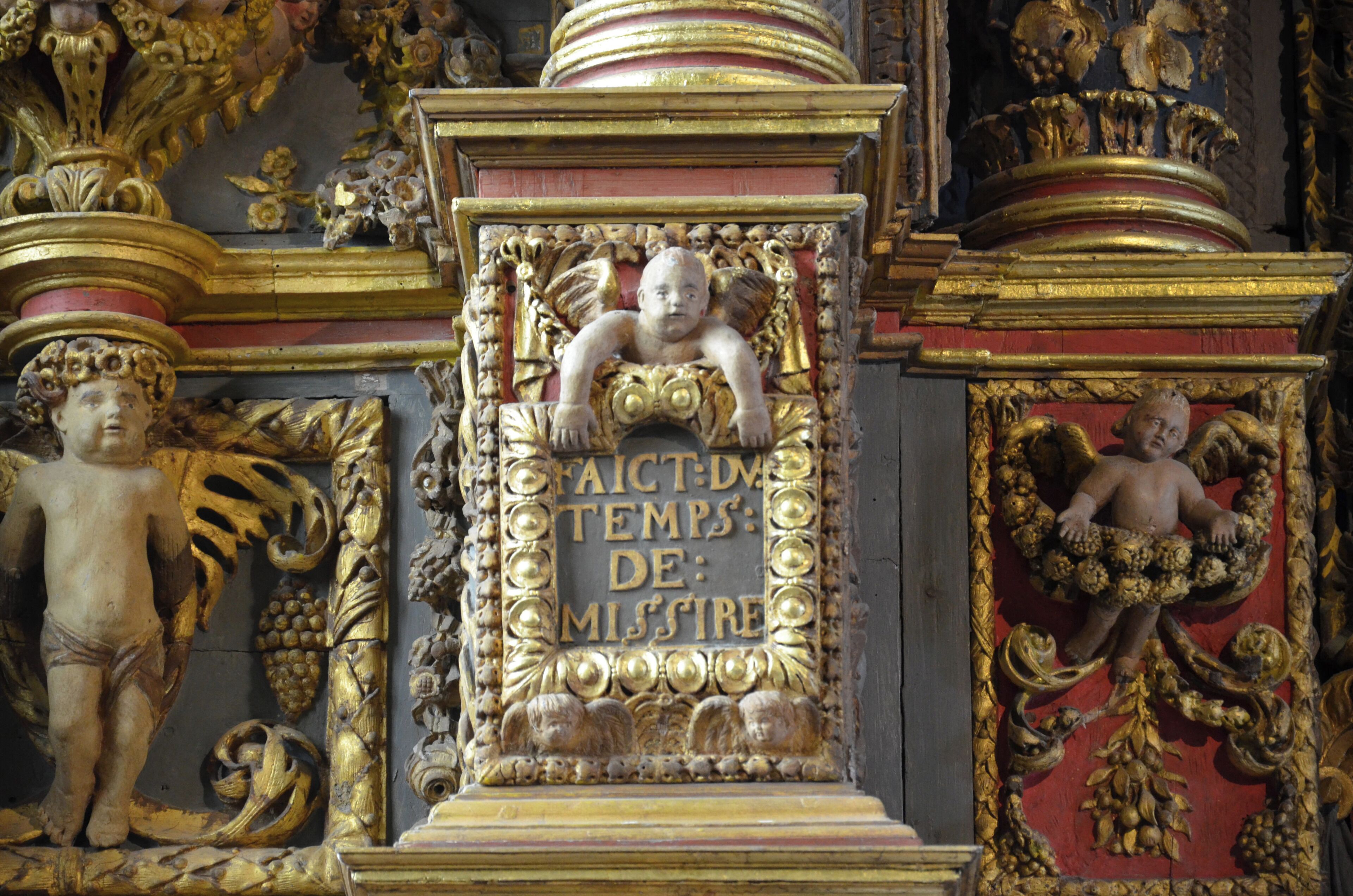 A golden ornate frame with a cherub and the inscription "FAICT-DA TEMPS: DE MISSIRE".