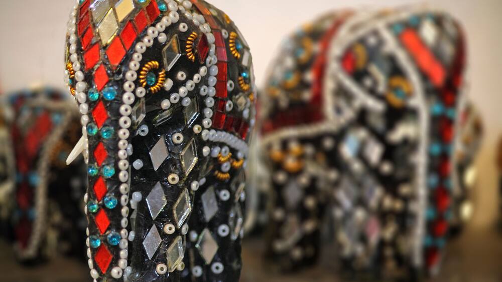 Un gros plan d’une tête d’éléphant ornée de bijoux, avec des motifs et des décorations complexes.
