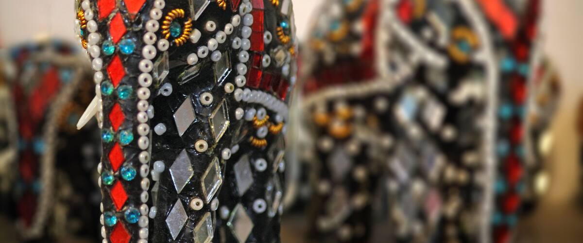 A close-up of a bejeweled elephant head with intricate patterns and decorations.