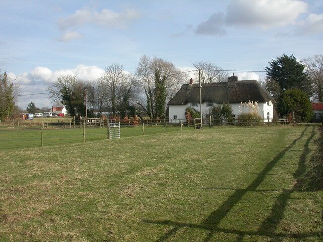 West Parley, Woodtown Farm. Isolated thatched farmhouse, reached by a track from the North at Christchurch Road, or, as here, by footpath (through galvanised gate, left of centre) from Church Lane 1171549. The farmhouse is English Heritage-listed http://www.imagesofengland.org.uk/Details/Default.aspx?id=107704&mode=adv