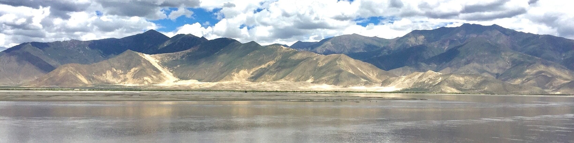 Una cordillera con una masa de agua reflectante al frente.