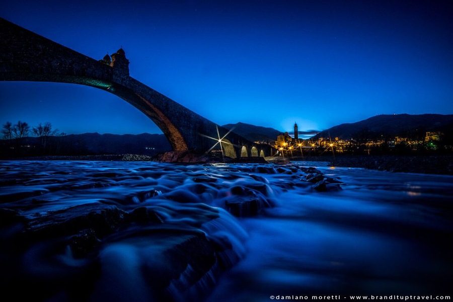 To avoid the risks of Trebbia’s unpredictable floods, legend has it that St. Columban made a pact with the Devil: in exchange for the construction of the bridge in one night only, Devil’s reward would be the soul of the first person who would cross it. The Devil respected the agreement and in one night he built the Old Bridge with the help of a group of demons of different height and build, cause however of the structure’s irregularity. When St. Columbanus, the next morning, saw the Hunchbacked Bridge, mocked the Devil by letting a dog be the first to cross it.
#blue