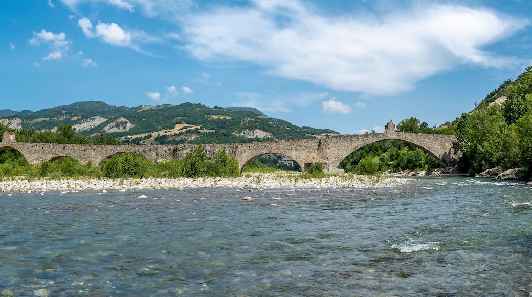 The Trebbia river flows under the ancient Gobbo bridge in Bobbio, Italy