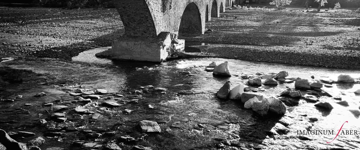 Bobbio is a small town in the province of Piacenza in Emilia-Romagna, northern Italy. It is located in the Trebbia River valley southwest of the town Piacenza, a valley described by Ernest Hemingway as "the most beautiful in the world". Depicted here is the Ponte Vecchio, called Ponte Gobbo (Hunchback Bridge), also known as the Devil's Bridge. It's an ancient stone bridge of Roman origin, which crosses the river Trebbia in eleven irregular arches.
