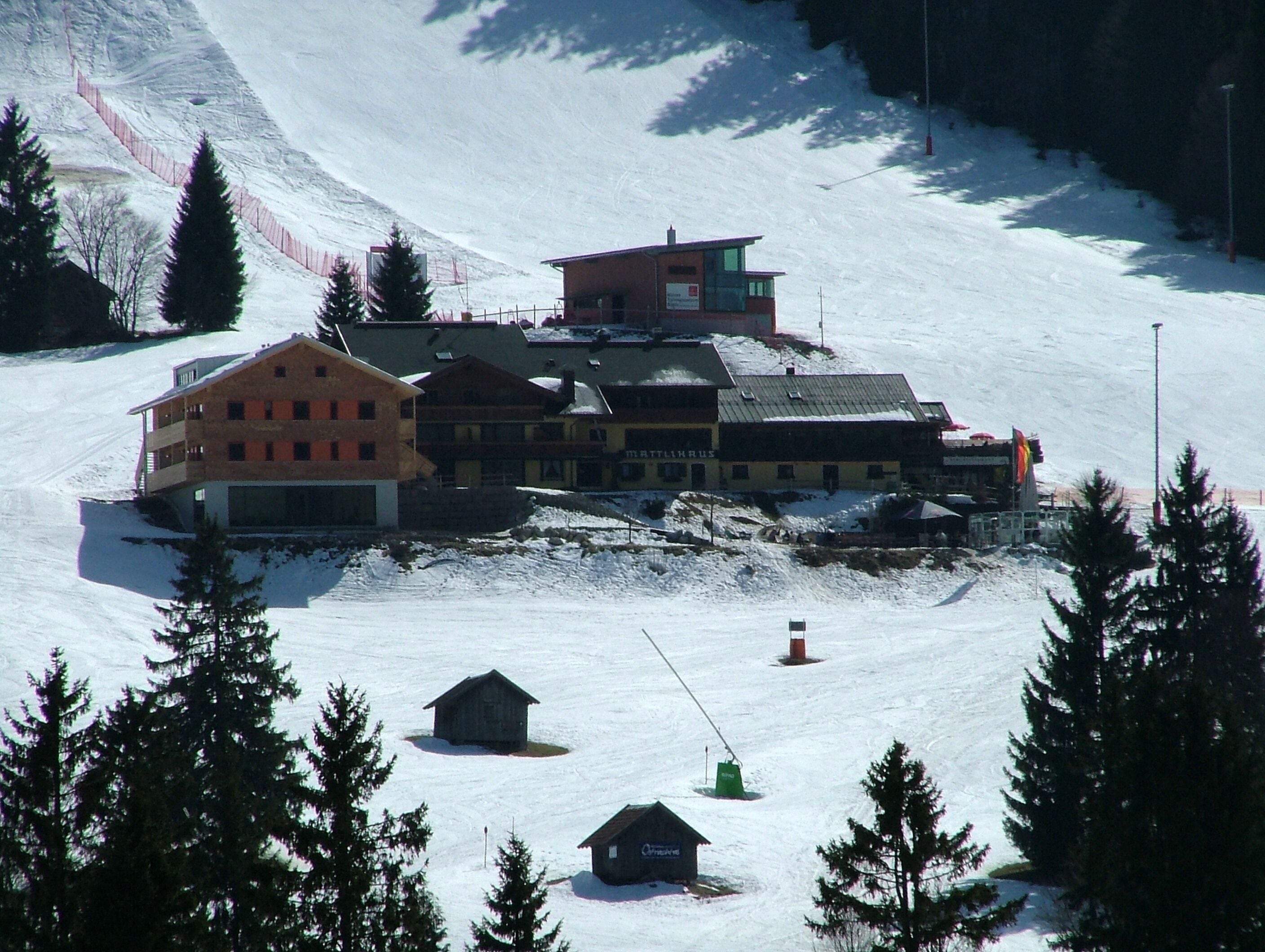 Un centro de esquí cubierto de nieve con edificios y un telesilla.