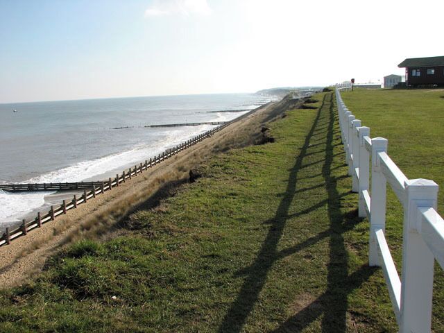 Eroding clifftop path A narrow path leads along the crumbling clifftop, skirting the adjoining caravan parks. The Norfolk coastline is almost 100 miles long and extends from Hopton, just south of Great Yarmouth, northwards past the seaside resorts of Winterton, Happisburgh, Mundesley, Cromer, Sheringham and Holkham before it merges into Lincolnshire at King's Lynn. After the devastating floods in 1953, where 300 people lost their lives, the first sea defences were built along the coastline and at first the rate of erosion decreased. However, large portions of the revetments have been destroyed during the last 40 years, despite repairs, and beach and cliff erosion continue. The Shoreline Management Plan in its present format proposes no active intervention for a number of villages along the East Anglian coast, leaving them unprotected. One of these villages is Hopton, situated several miles south of Great Yarmouth, where the southern end of the Hopton to Corton seawall had to be closed due to storm damage, with the anticipation of a collapse of the structure > https://www.geograph.org.uk/photo/1717919. A warning for walkers to take extra care has also been placed at the clifftop path > https://www.geograph.org.uk/photo/1717876 where cliff falls on the path to Corton have occurred recently and more are expected > https://www.geograph.org.uk/photo/1717883. Some blame the existence of the new outer harbour in Great Yarmouth for the loss of sand and beach area, and although some of the sand has since returned it is still at a low level. The privately owned East Port at Great Yarmouth, a multi-purpose facility integrating a new deep-water outer harbour, was opened in May 2007.