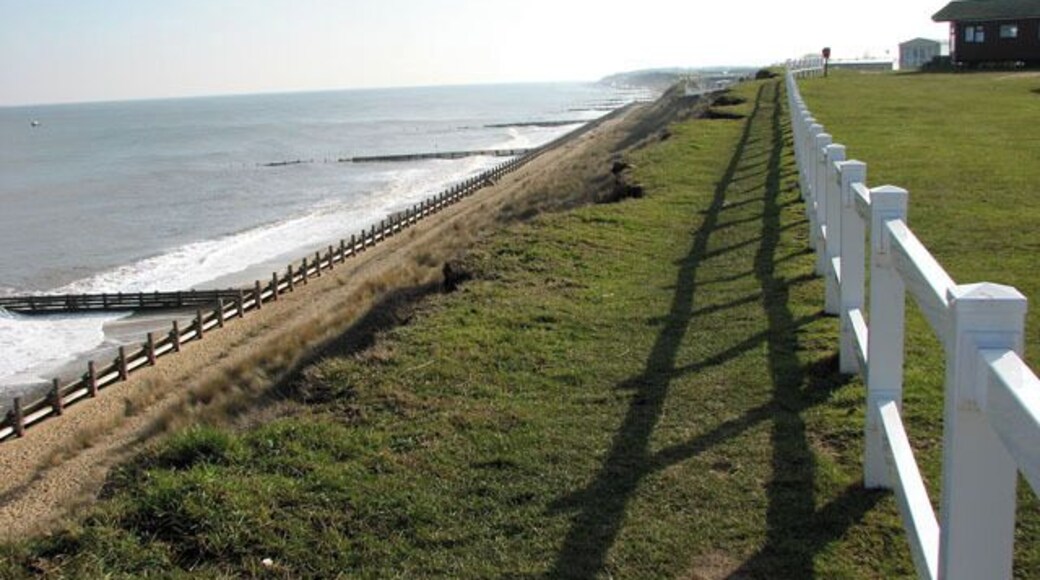 Eroding clifftop path A narrow path leads along the crumbling clifftop, skirting the adjoining caravan parks. The Norfolk coastline is almost 100 miles long and extends from Hopton, just south of Great Yarmouth, northwards past the seaside resorts of Winterton, Happisburgh, Mundesley, Cromer, Sheringham and Holkham before it merges into Lincolnshire at King's Lynn. After the devastating floods in 1953, where 300 people lost their lives, the first sea defences were built along the coastline and at first the rate of erosion decreased. However, large portions of the revetments have been destroyed during the last 40 years, despite repairs, and beach and cliff erosion continue. The Shoreline Management Plan in its present format proposes no active intervention for a number of villages along the East Anglian coast, leaving them unprotected. One of these villages is Hopton, situated several miles south of Great Yarmouth, where the southern end of the Hopton to Corton seawall had to be closed due to storm damage, with the anticipation of a collapse of the structure > https://www.geograph.org.uk/photo/1717919. A warning for walkers to take extra care has also been placed at the clifftop path > https://www.geograph.org.uk/photo/1717876 where cliff falls on the path to Corton have occurred recently and more are expected > https://www.geograph.org.uk/photo/1717883. Some blame the existence of the new outer harbour in Great Yarmouth for the loss of sand and beach area, and although some of the sand has since returned it is still at a low level. The privately owned East Port at Great Yarmouth, a multi-purpose facility integrating a new deep-water outer harbour, was opened in May 2007.