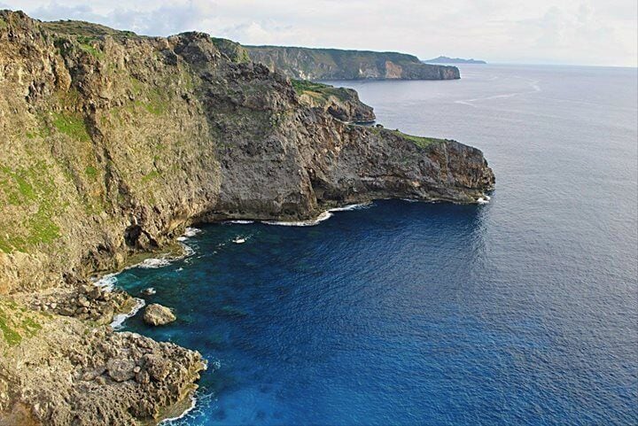 A rugged coastline with steep cliffs and a deep blue sea.