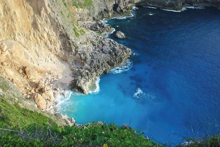 A coastal cliff with a deep blue sea.