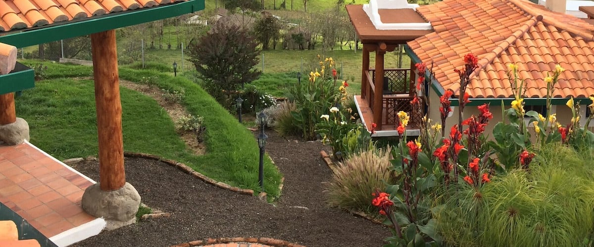 A garden with a gazebo, a patio, and a view of rolling hills.