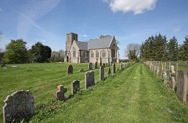 A church with a graveyard in front.