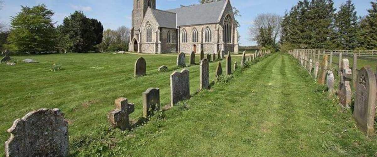 A church with a graveyard in front.