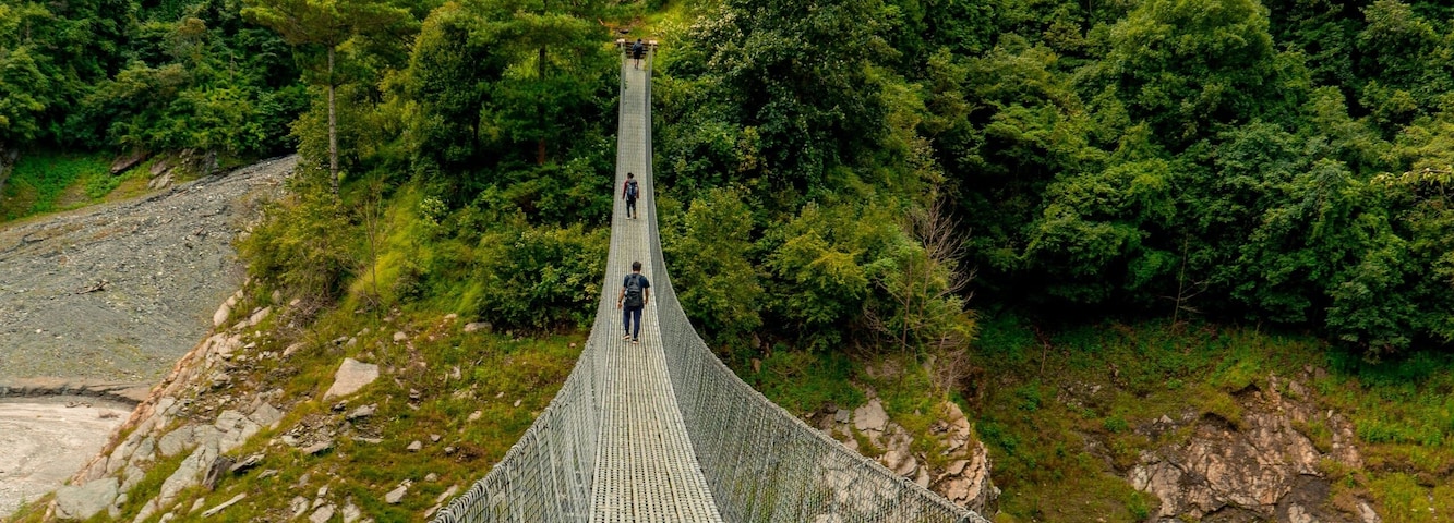 Vertical shot of a suspension bridge and dense forest on the background in Markhu, Makwanpur, Nepal