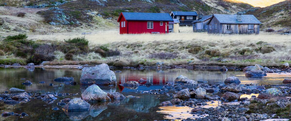 A red house, a blue house, and a rocky stream.