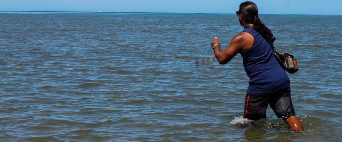 A person flying a kite in the water.