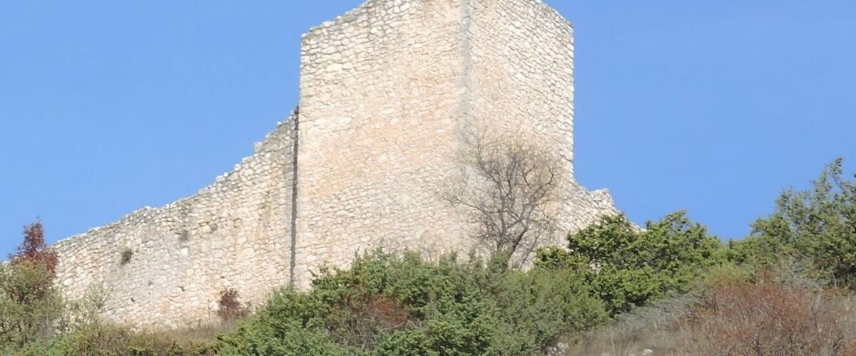A stone castle with multiple towers and a clear blue sky.