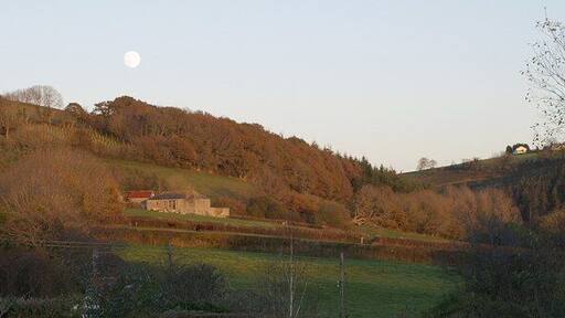 Higher Harford Farm outbuildings under Trunelshute Wood and under a full moon. From this square, the foothills of Exmoor start to rise. Seen from Landkey Footpath 16.