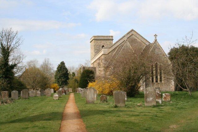A church with a stone facade and a graveyard with headstones.