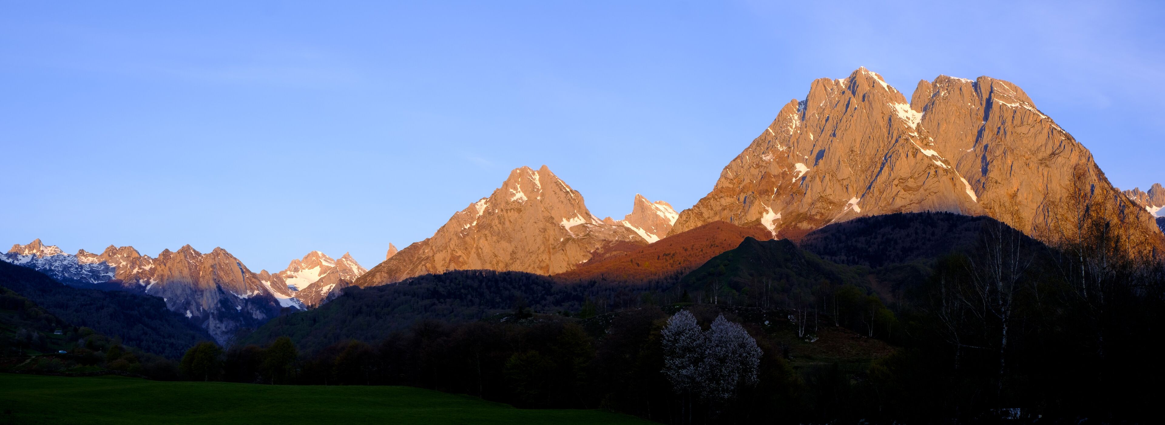 A mountain range with snow-capped peaks and a clear sky.