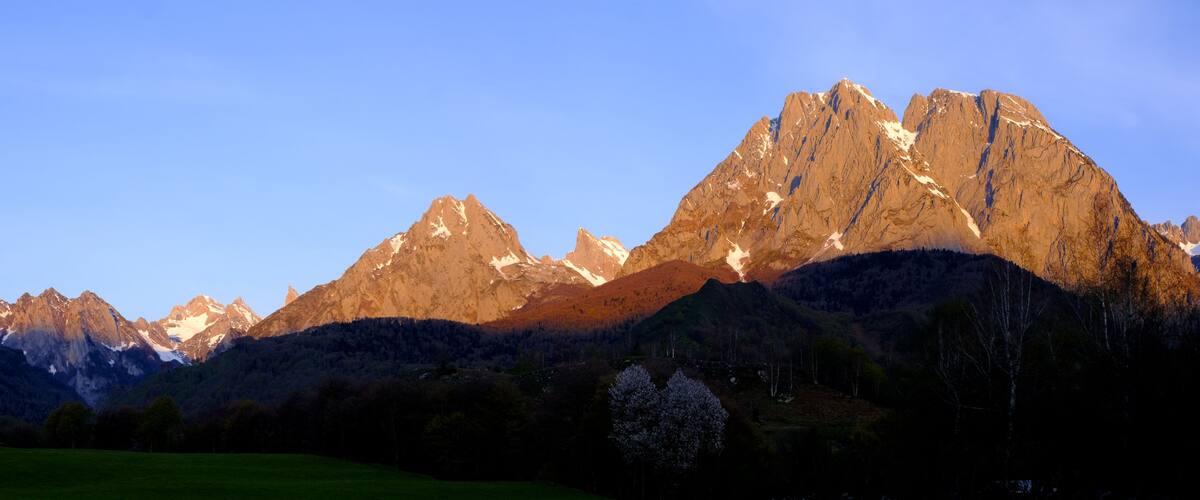 A mountain range with snow-capped peaks and a clear sky.
