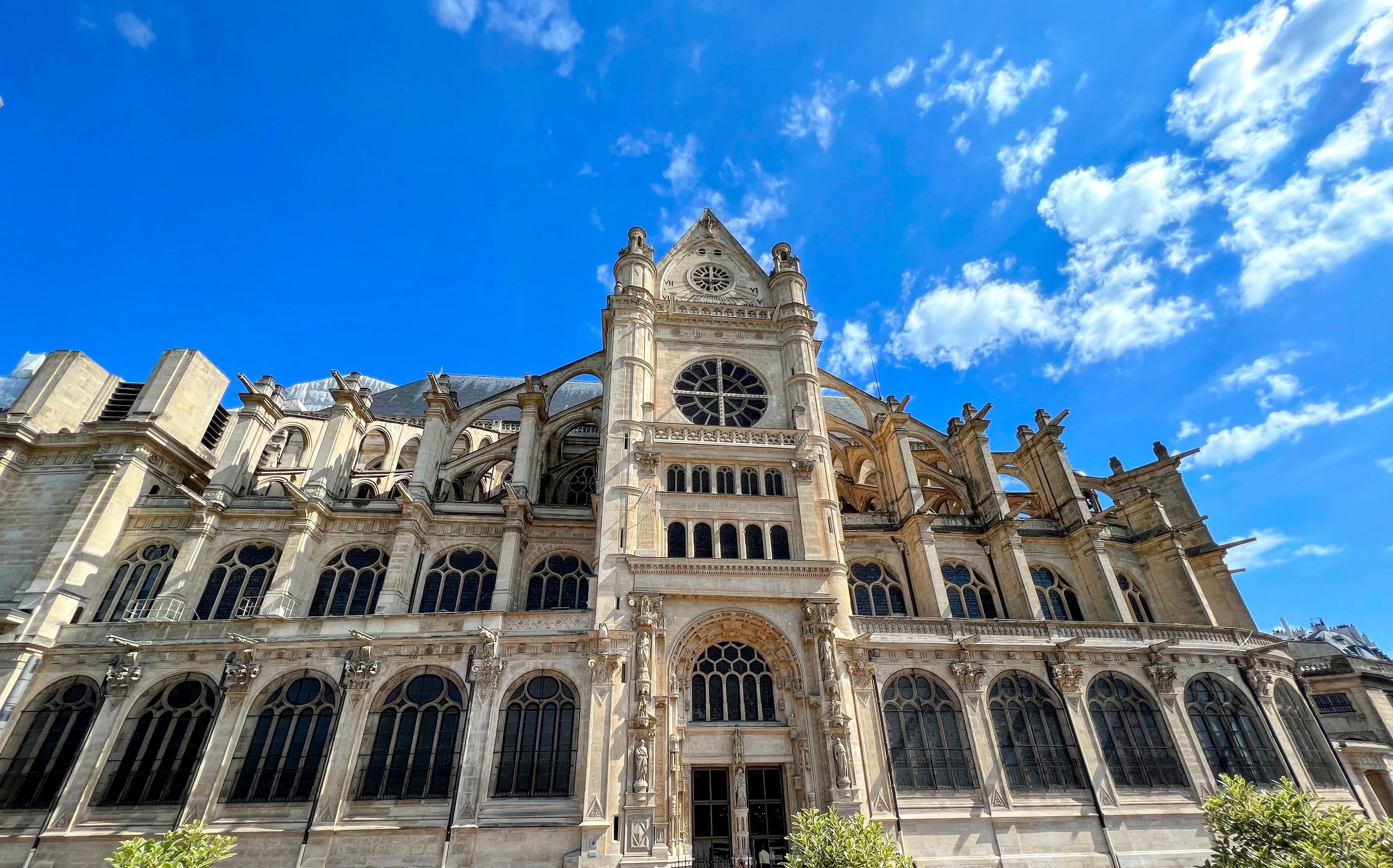 A large, ornate cathedral with a prominent clock tower and multiple statues.