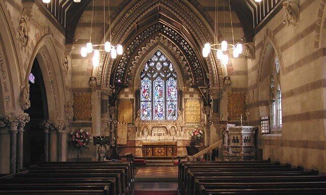 An interior of a church with Gothic architecture, including pointed arches and stained glass windows.