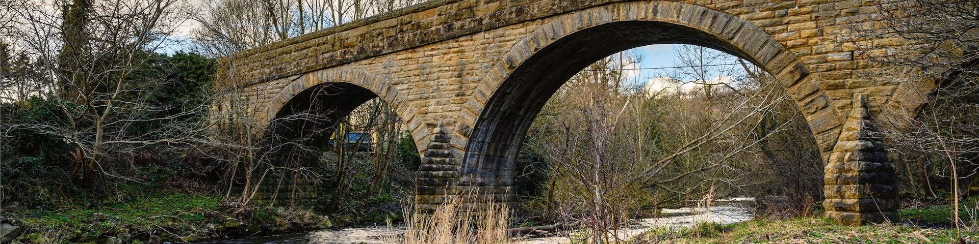 River Derwent flows under Ebchester Old Bridge, formed by the meeting of two burns in the North Pennines and flows between the boundaries of Durham and Northumberland as a tributary of the River Tyne