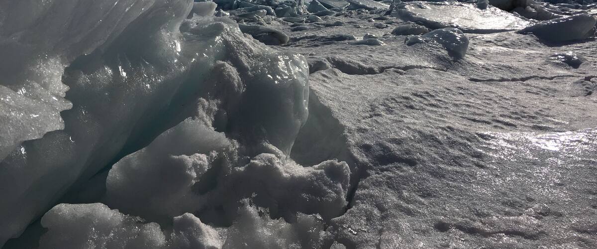 A snowy landscape with large ice formations and a clear blue sky.