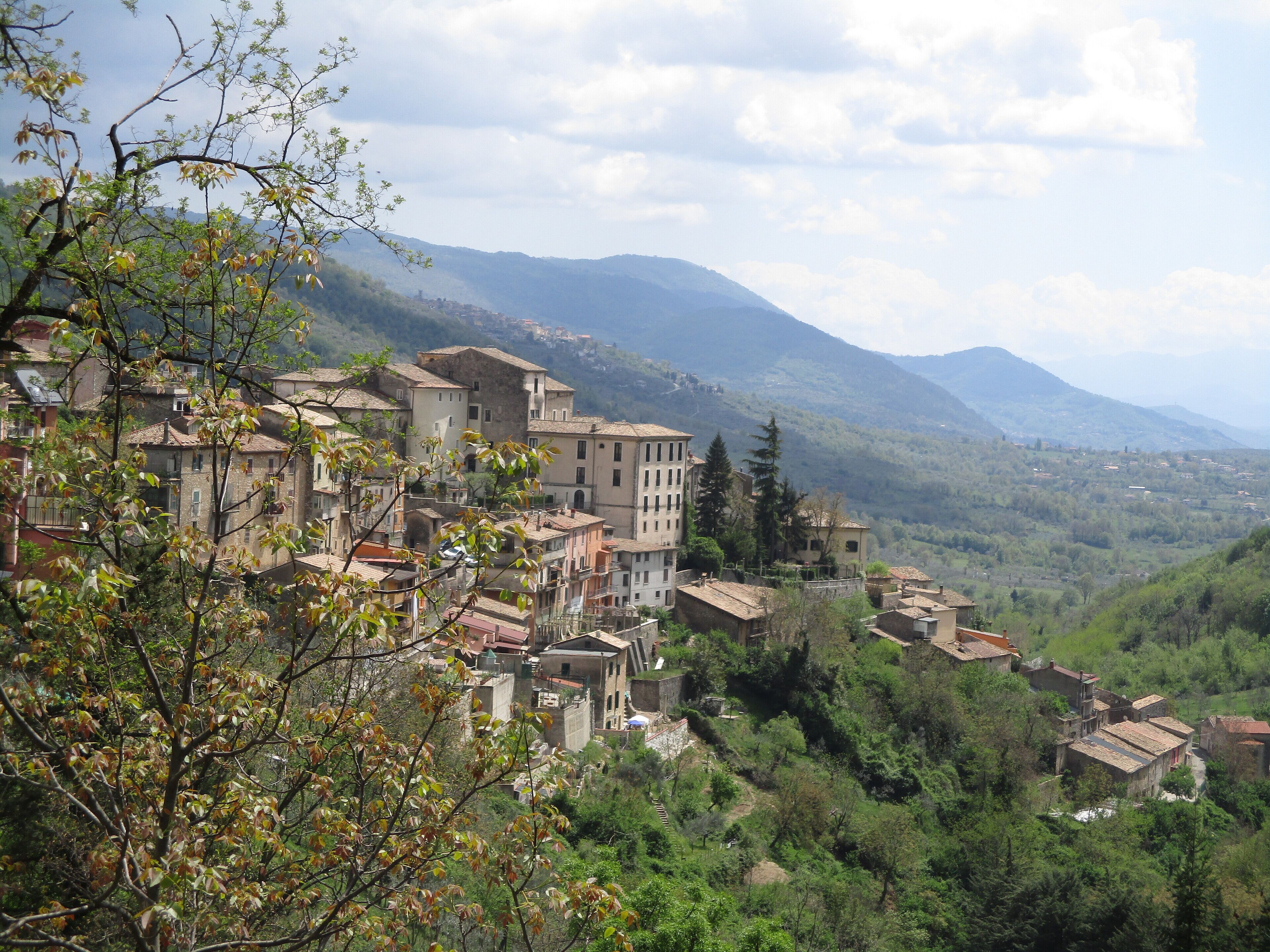 A mountainous village with traditional buildings nestled among lush greenery.