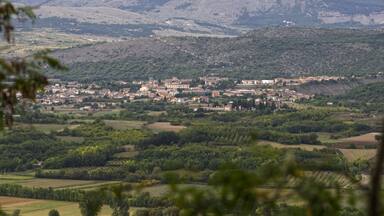 A town nestled in a valley with surrounding hills and mountains.