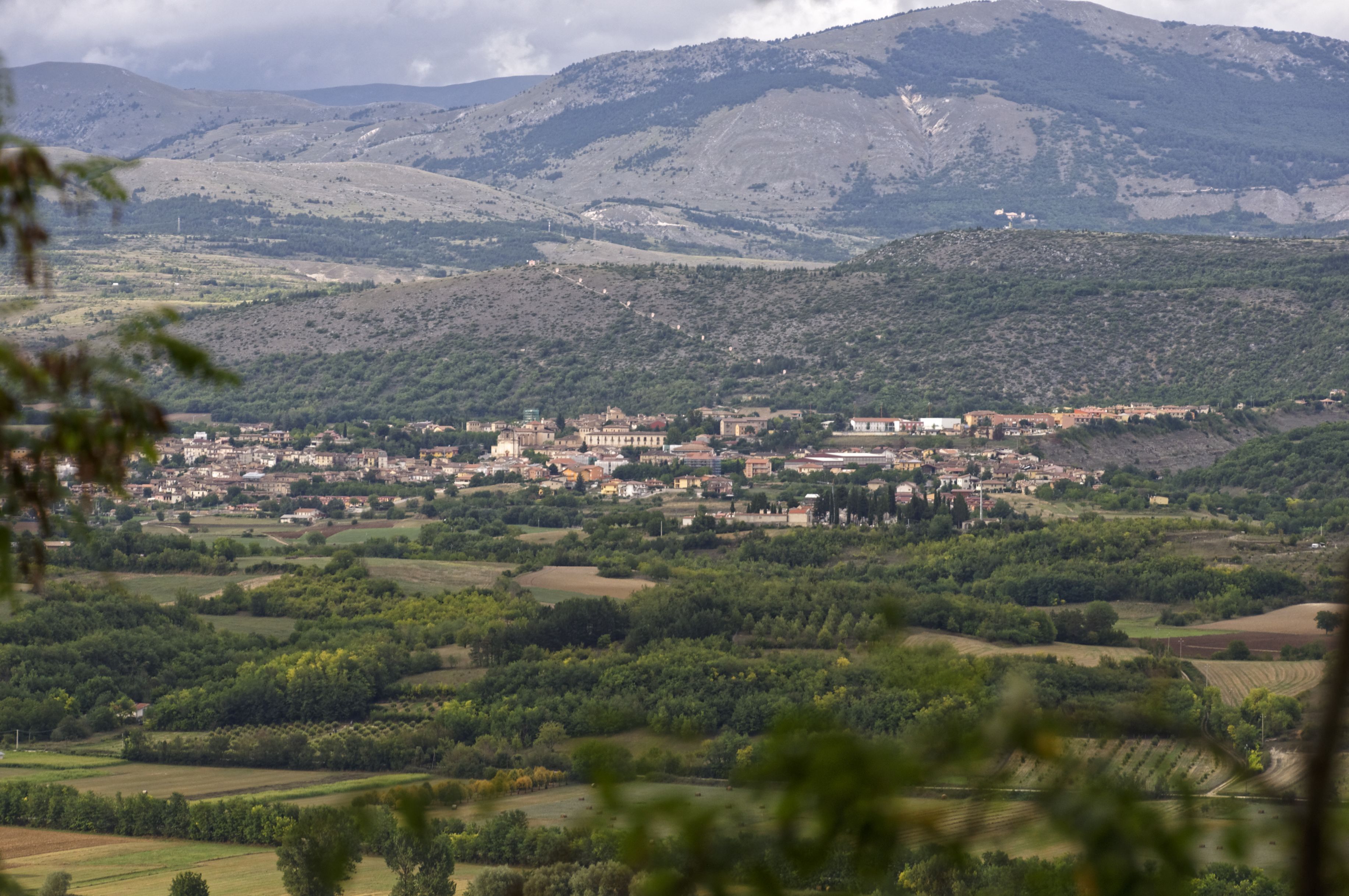 A town nestled in a valley with surrounding hills and mountains.