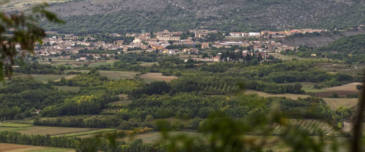 A town nestled in a valley with surrounding hills and mountains.