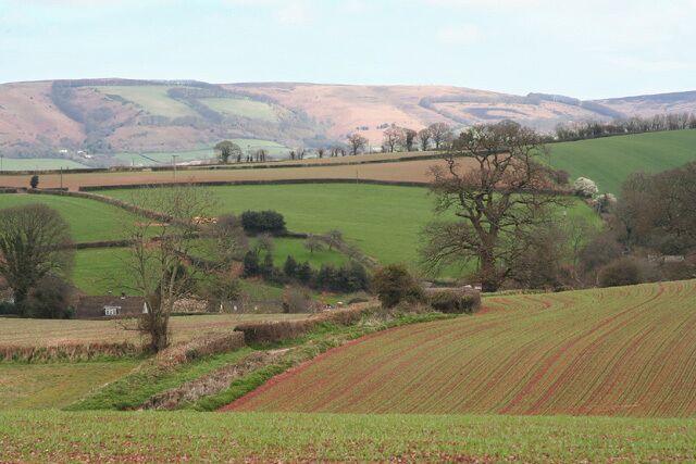 Rolling hills, fields, and a rural landscape with a distant view of a hill.