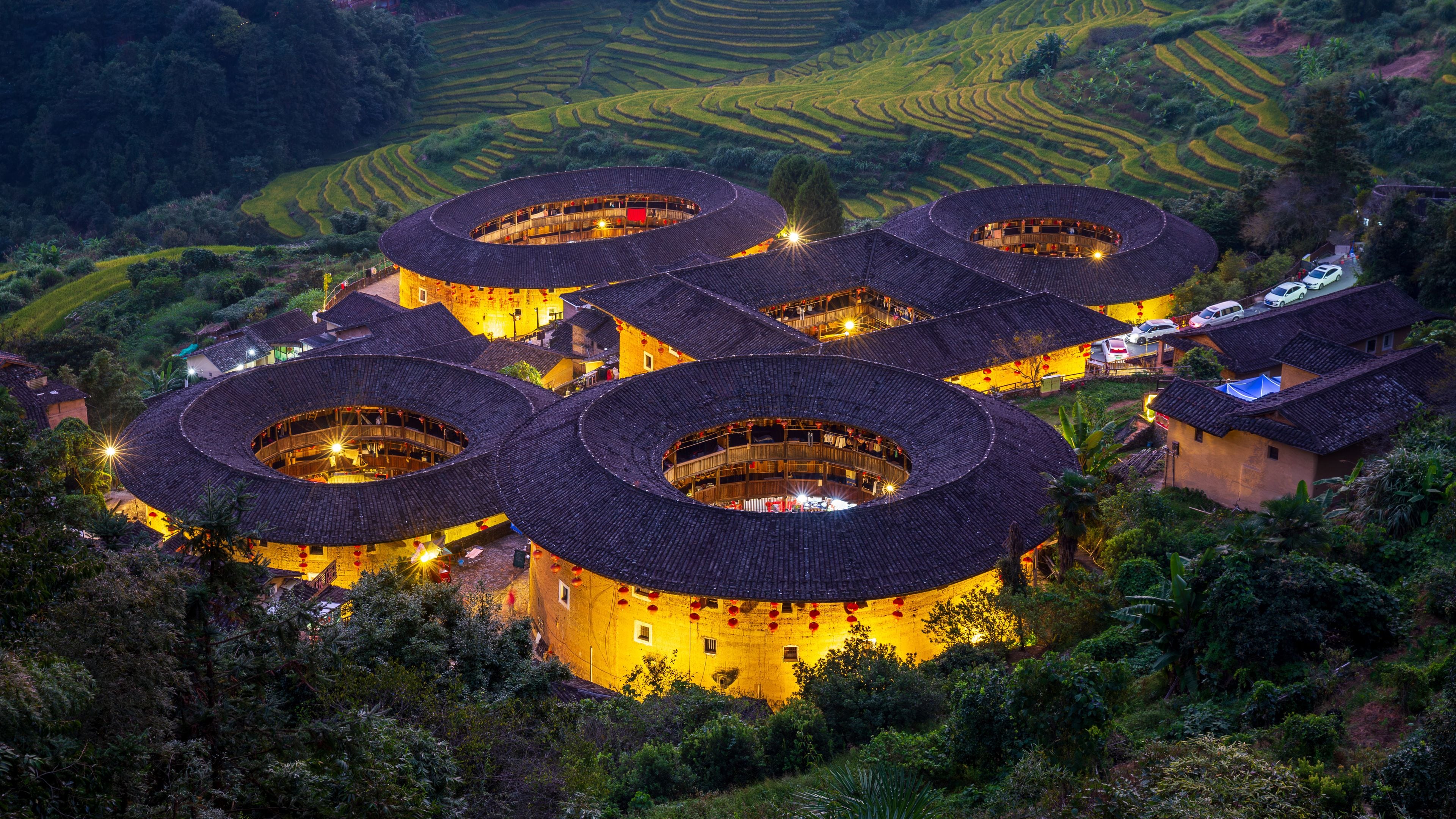 A traditional village with circular-roofed buildings surrounded by terraced fields.