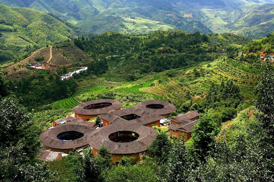 Campos escalonados, casas tradicionales con techos circulares y colinas verdes exuberantes.