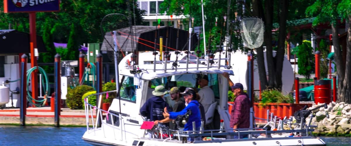 A boat with people on it near a dock with a sign for a ship store.