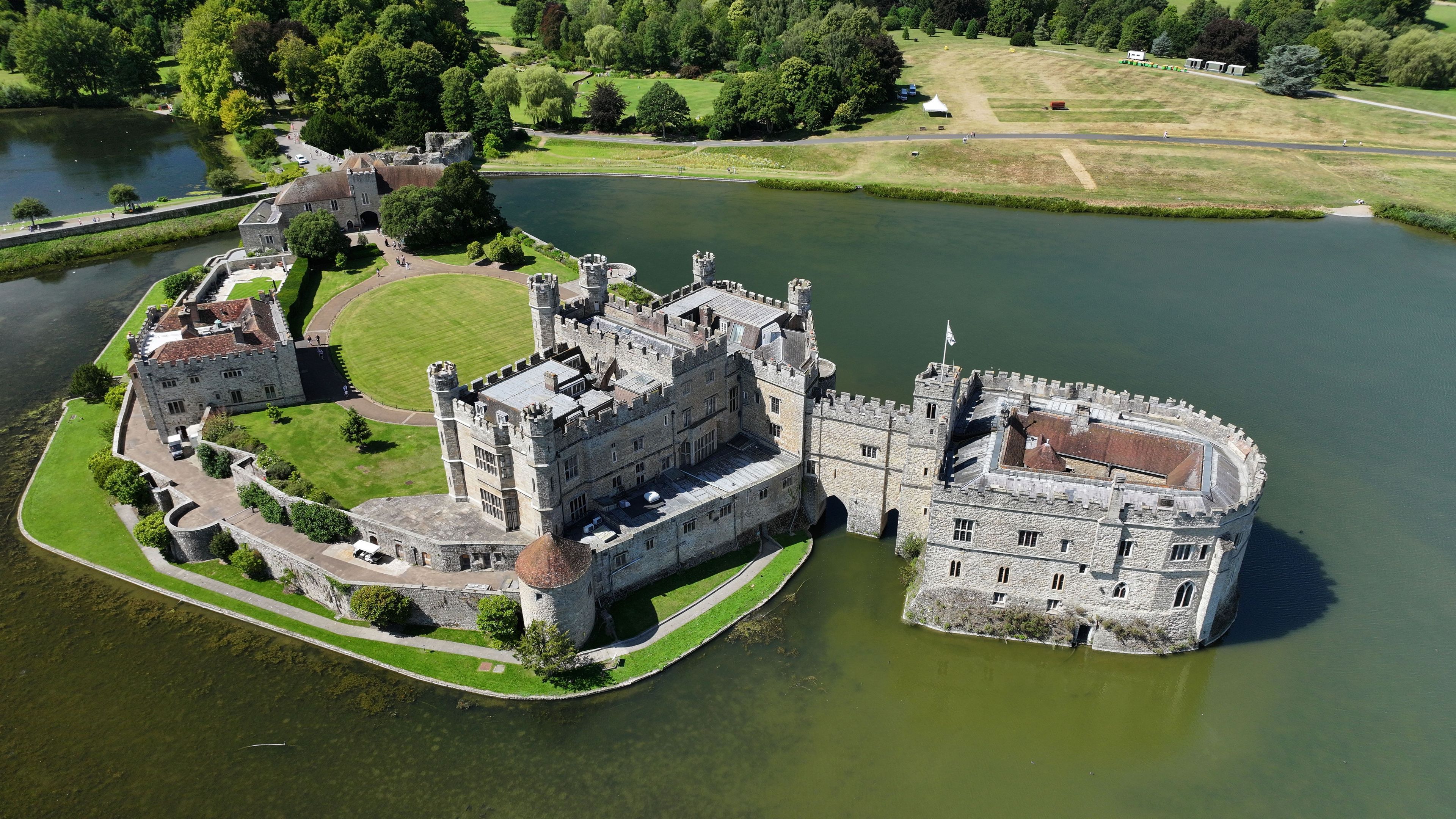 Un château historique entouré de douves et d’une végétation luxuriante.