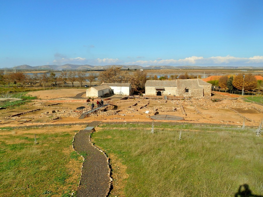 An archaeological site with stone buildings and a winding path.