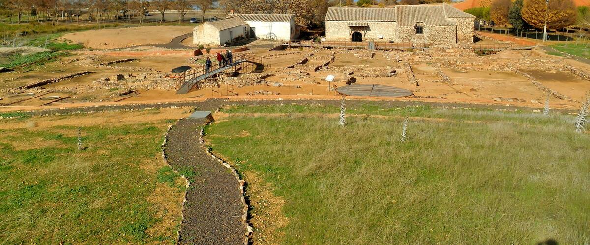 An archaeological site with stone buildings and a winding path.