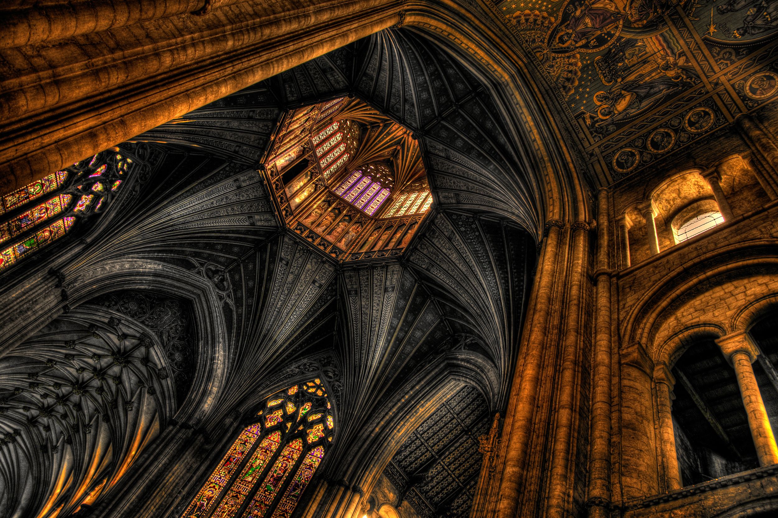 A cathedral interior with intricate stained glass windows and detailed stone carvings.