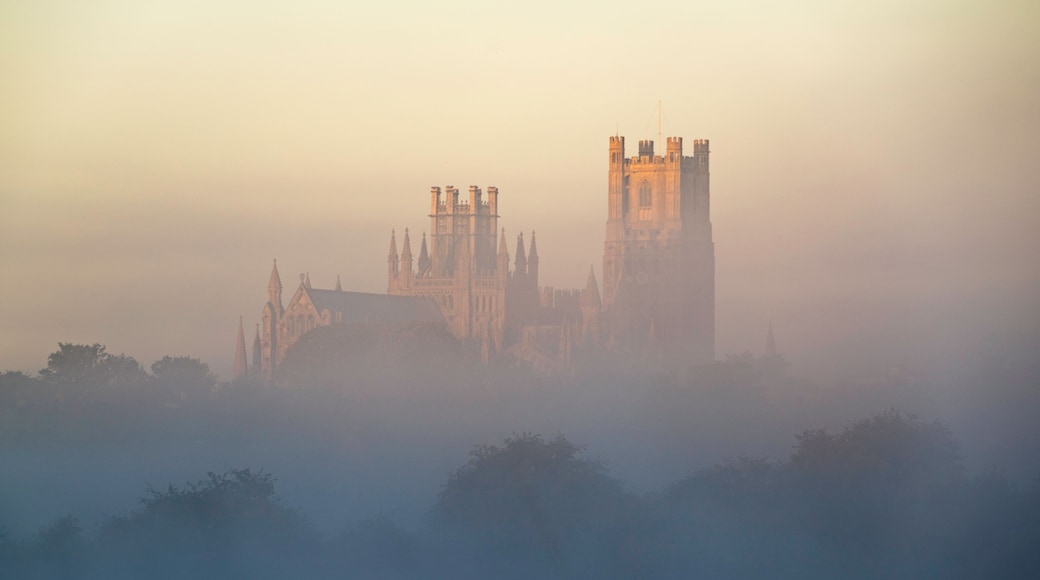 A historic castle with multiple towers and spires, surrounded by a misty landscape.
