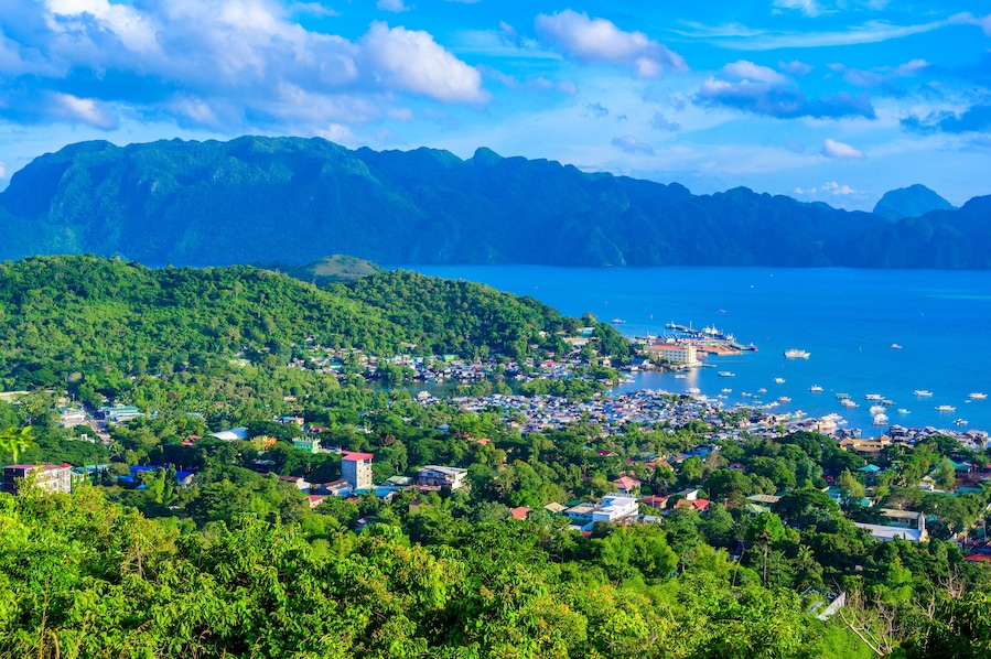 View of Coron Town and Bay from Mount Tapyas on Busuanga Island at sunset - tropical destination with paradise landscape scenery, Palawan, Philippines.
