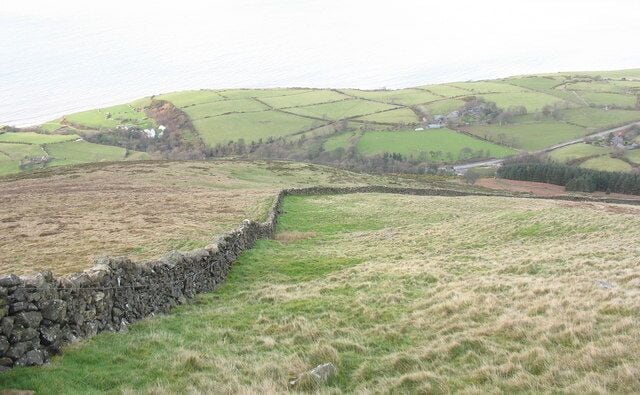 Looking downslope to the sharp bend in the boundary wall