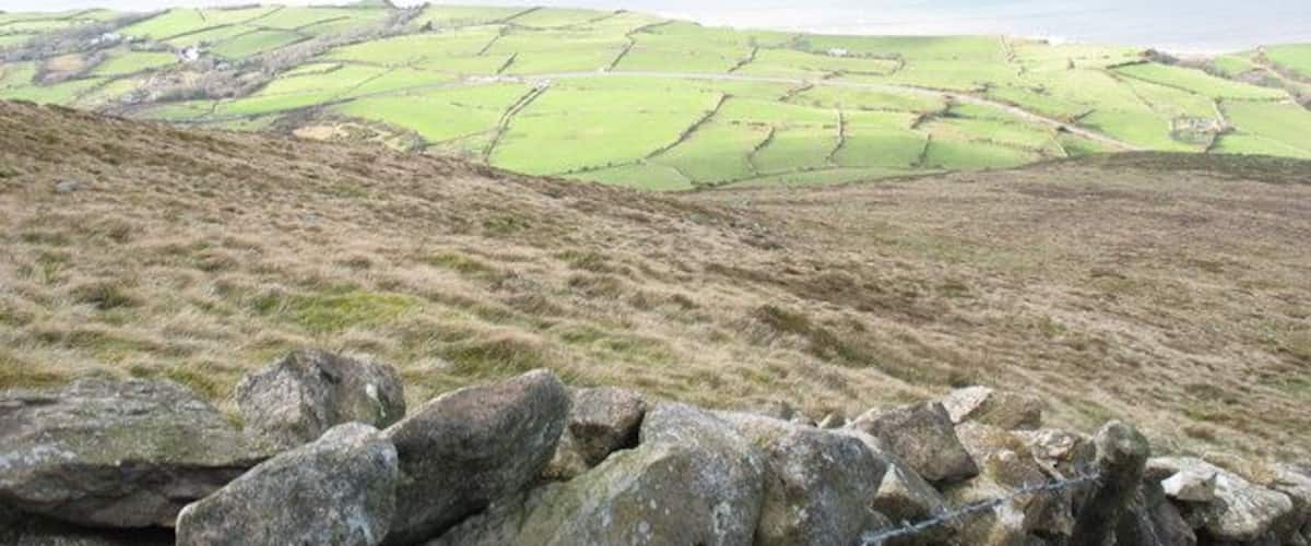 The western slope of Gyrn Goch The rough pasture of the large mountainside ffriths contrasts with the green of the tiny fields of the littoral strip.