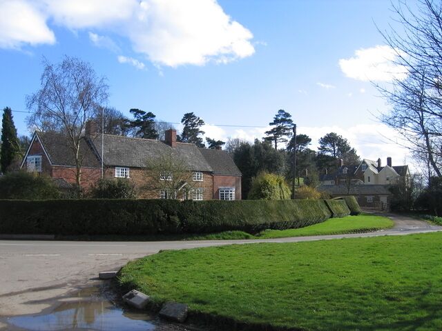 Priors Hardwick. Some of the substantial old houses with neat topiary beside the road towards Stoneton and Wormleighton. Looking ESE from the junction with the byway in the north of the square.